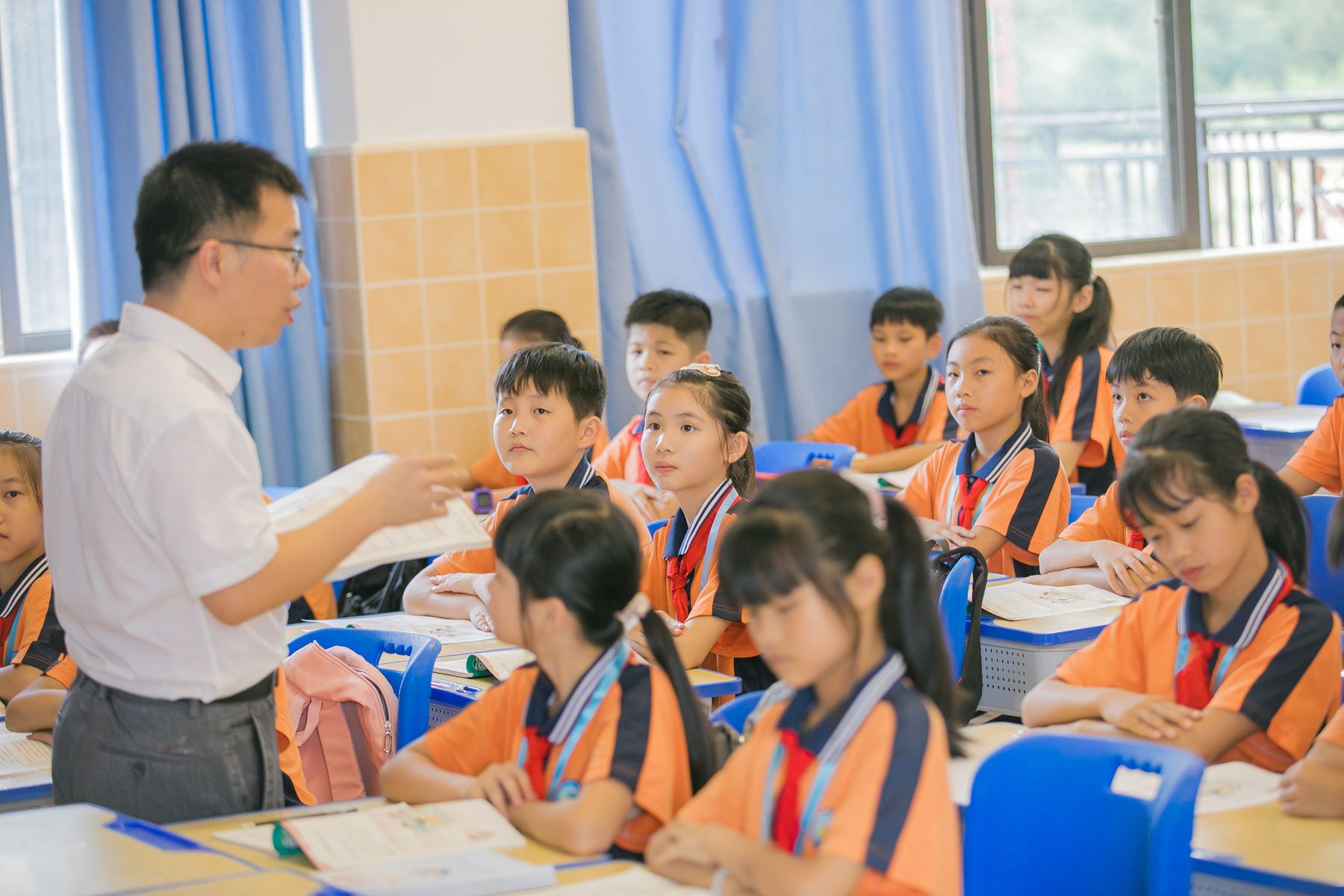 教室で先生の話を聞きながら学ぶ子どもたちのイメージ写真