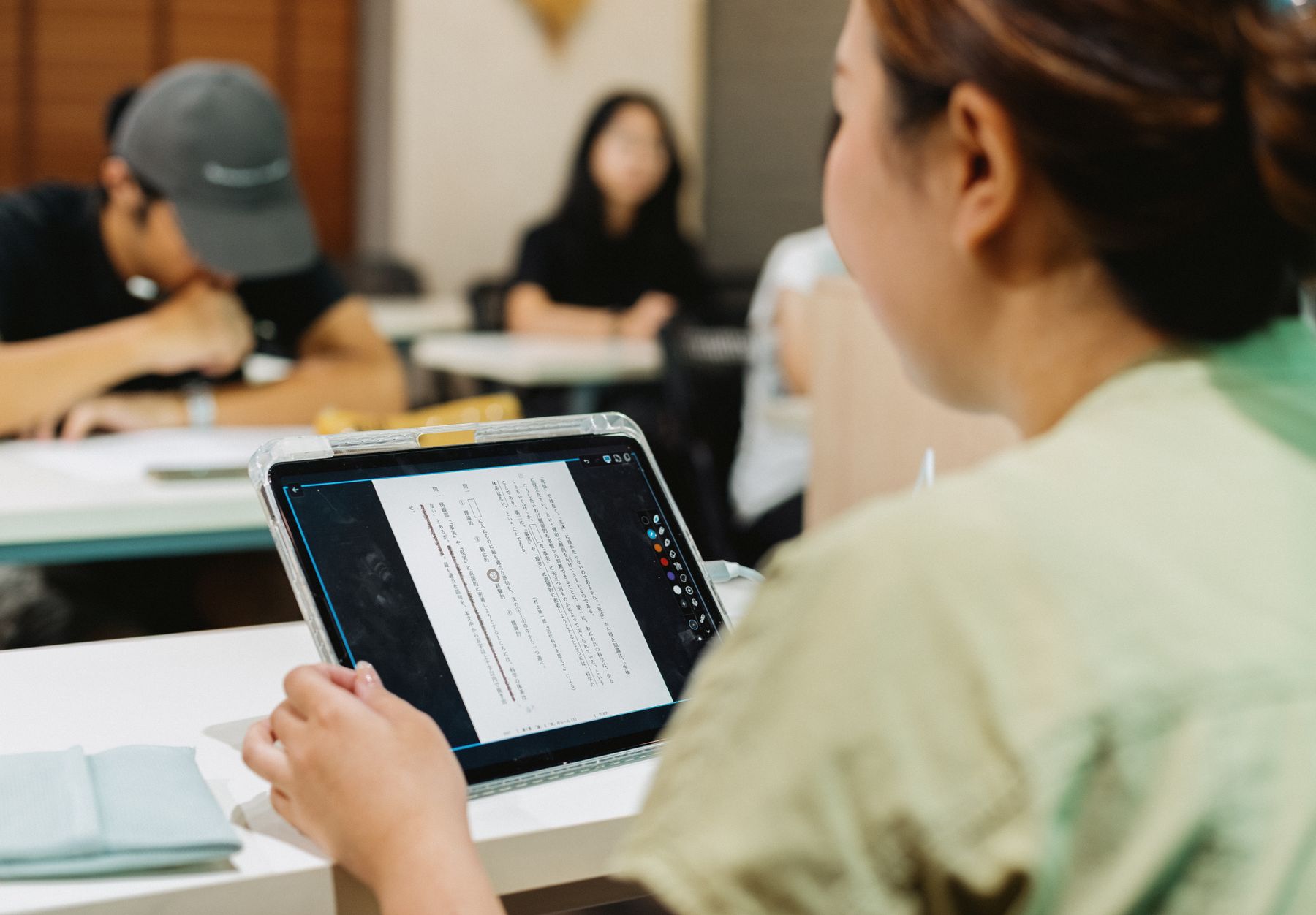 教室でデジタル教材を使って学ぶ学生